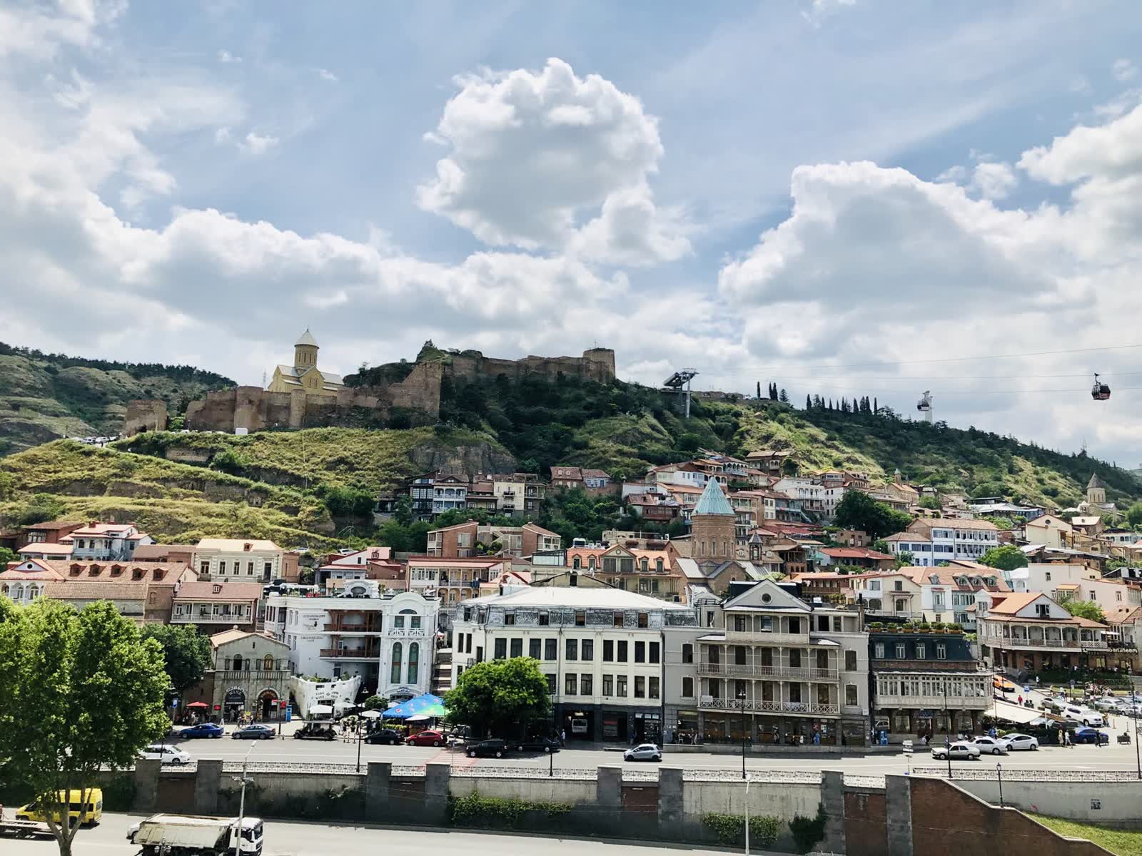 Old Tbilisi houses climbing the hillside below Narikala fortress, above the Kura river